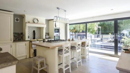 a kitchen with a large kitchen island with stools at 8-10 Bed, Spacious House in Cheltenham