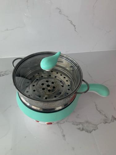 a pot with a spoon sitting on top of it at Pakuwon ORCHARD Apartment by Dovey in Surabaya