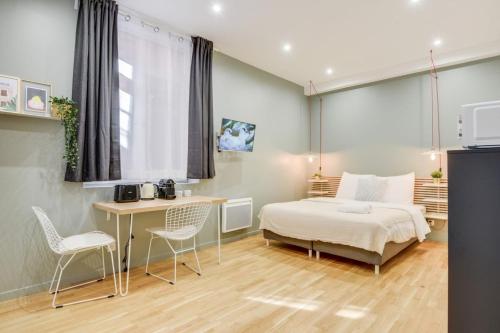 a bedroom with a bed and a table and chairs at Lille Centre - Nice studio in Lille