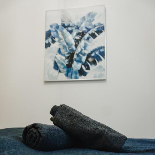 a towel laying on top of a couch with a painting at Lighthouse Hostel & Rooms in Rīga