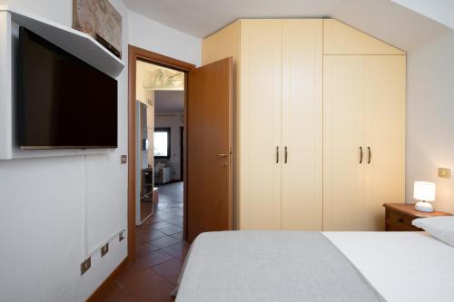 a bedroom with a bed and a flat screen tv at I Lecci 1 by Klodge in Olbia