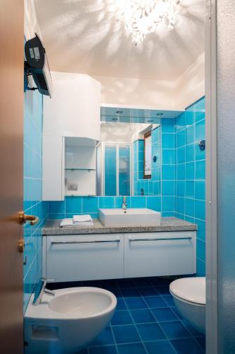 a blue bathroom with a sink and a toilet at I Lecci 1 by Klodge in Olbia