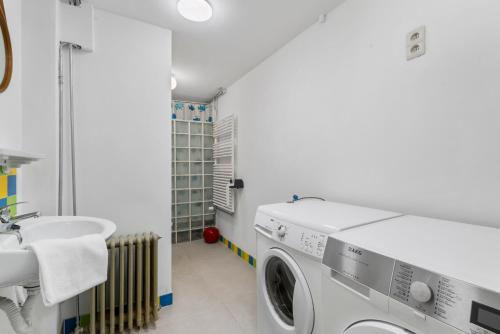 een wasmachine in een badkamer met een wastafel bij Karaktervolle en ruime woning aan zee voor 10p in Oostende