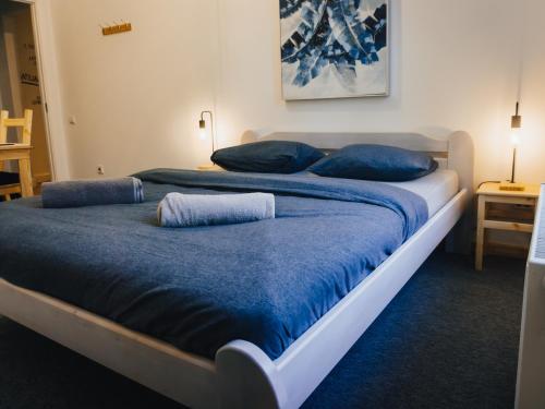 two beds in a room with blue sheets and pillows at Lighthouse Hostel & Rooms in Rīga