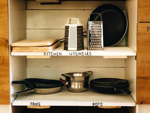 a shelf with various kitchen utensils on it at Lighthouse Hostel & Rooms in Riga