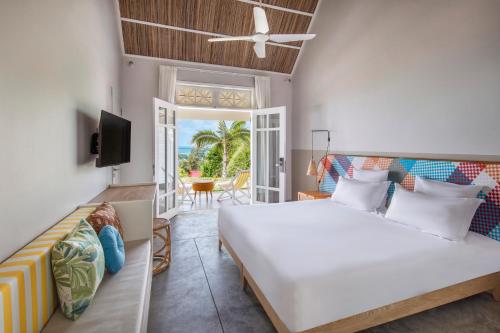 - une chambre avec un grand lit et un balcon dans l'établissement C Rodrigues Mourouk, à Rodrigues Island