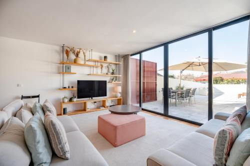 a living room with a white couch and a tv at VIVA Serralves Patio in Porto