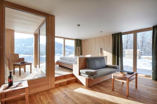 1 dormitorio con cama, sofá y mesa en Genießer - & Romantik Hotel DAS SCHIFF en Hittisau