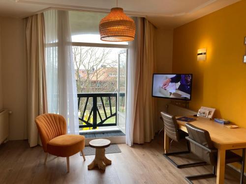 ein Wohnzimmer mit einem Tisch und einem großen Fenster in der Unterkunft Plato by Hofstad Studio’s in Scheveningen