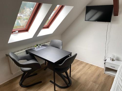 a dining room with a black table and chairs at FeWo WIEKO Plauen Leibnizstr. H1, DG rechts in Plauen