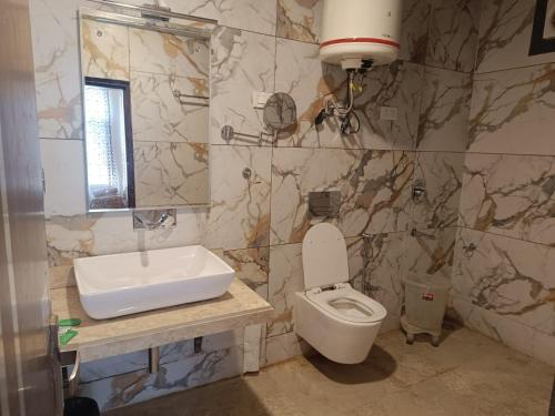 y baño con lavabo, aseo y espejo. en The Hotel Influence, en Pahalgām