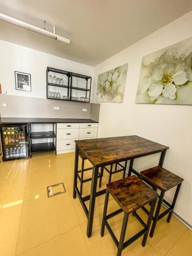 a kitchen with a wooden table and two stools at Slunečný Penzion in Tasovice