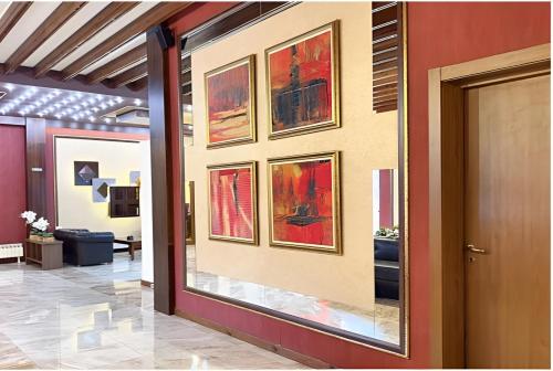 a hallway with paintings on the wall in a building at Platinum Hotel and Casino Bansko in Bansko