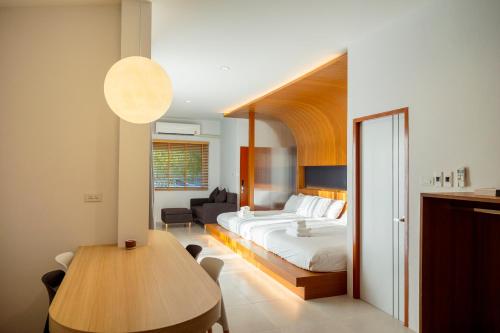 a bedroom with a bed and a table in a room at Karpenter Lampang in Lampang