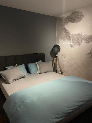 a bedroom with a large bed with blue pillows at Šantić in Novi Sad