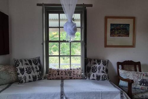 - une chambre avec un lit et une fenêtre dans l'établissement Bailey's Riverside Cottage - Go Green!, à Calitzdorp