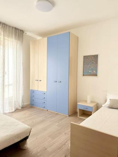 a bedroom with two beds and a blue cabinet at Casa in centro storico Lago di Garda in Castelnuovo del Garda
