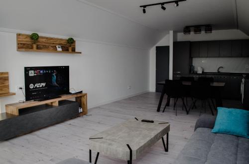 een woonkamer met een bank, een tv en een tafel bij PentGarden penthouse jacuzzi in Târgu Jiu