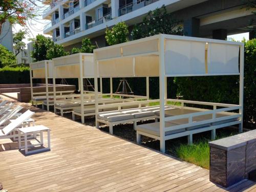 a row of white benches sitting on a deck at Baan Sankraam by Baan Captainreua Sankraam in Cha Am