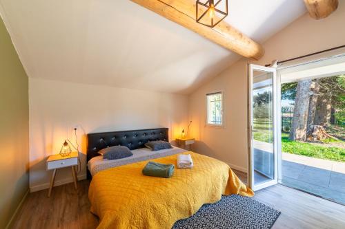 une chambre avec un lit et une grande fenêtre dans l'établissement Gîte du Mas Saint Paul - Maison avec piscine, à Travaillan