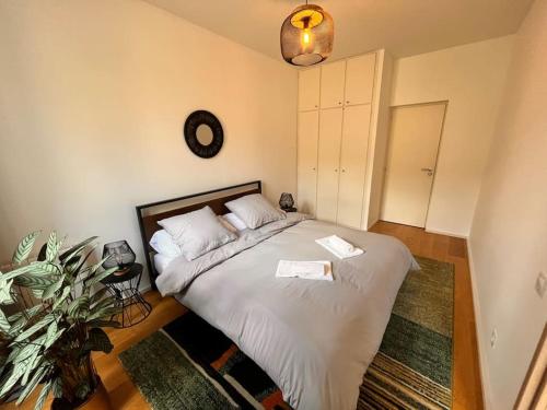 een slaapkamer met een bed en een klok aan de muur bij Beautiful Apartment in City Center in Bordeaux