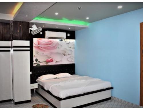 Cette chambre comprend un lit orné d'une peinture murale. dans l'établissement Hotel Sonar Gaon, Agartala, à Agartala
