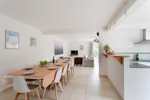une salle à manger et une cuisine avec une grande table et des chaises dans l'établissement La Camillette - 5 chambres à 10min de la plage, à Pléneuf-Val-André