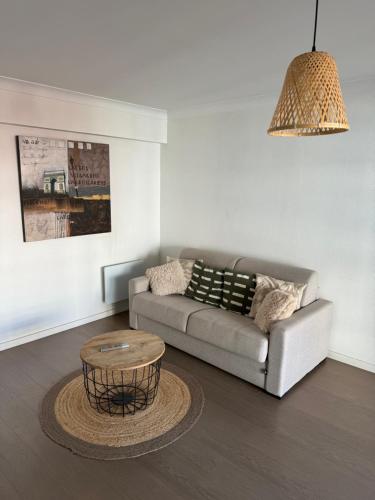 un salon avec un canapé et une table basse dans l'établissement Modern 60m2 apartment with 2 balconies, at 50 meters from sea, à Antibes