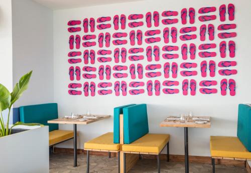 a dining room with tables and a large art piece on the wall at C Rodrigues Mourouk in Rodrigues Island