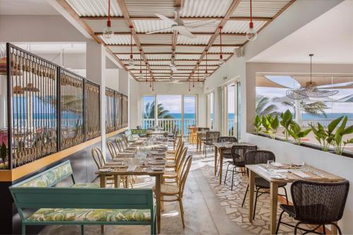 un restaurante con mesas y sillas y el océano en C Rodrigues Mourouk en Rodrigues Island