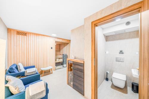 Dům u Prokopského údolí في براغ: حمام به أريكة زرقاء ومغسلة