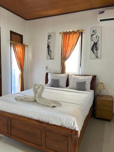 a bedroom with a large bed with a swan on it at Bima Homestay Lembongan in Nusa Lembongan
