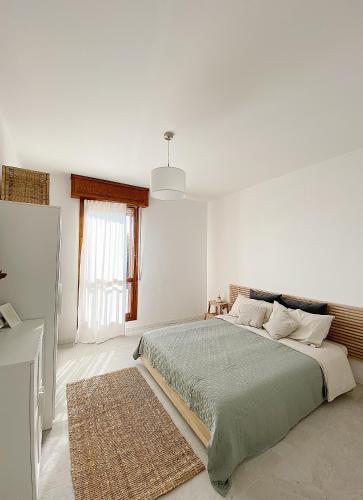 ein weißes Schlafzimmer mit einem Bett und einem Fenster in der Unterkunft Moderno, ristrutturato, 1 km dal centro storico! in Carpi