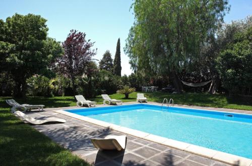 - une piscine dans une cour avec des chaises longues dans l'établissement Anna e Gaetano, à Misterbianco