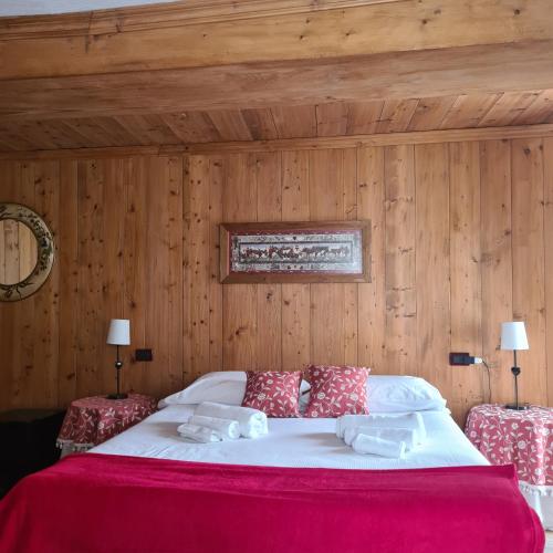 a bedroom with a large bed with wooden walls at Hotel Dente Del Gigante in Courmayeur