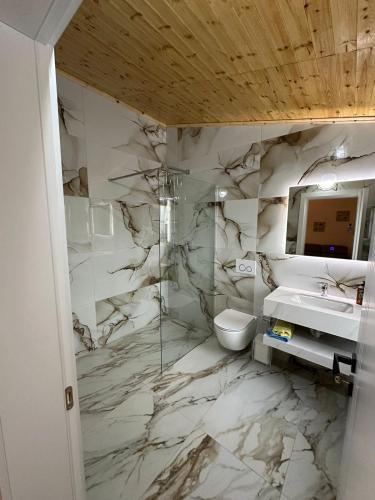 a bathroom with a sink and a toilet and a mirror at Qyteza Guest House & Camping in Renc