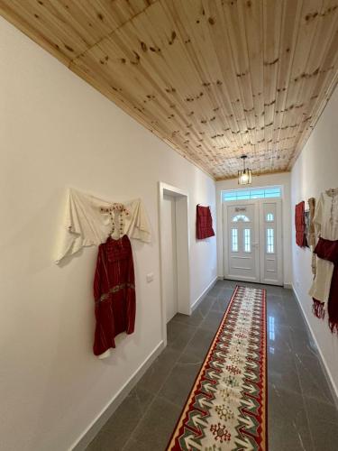 a hallway with clothes hanging on the wall and a rug at Qyteza Guest House & Camping in Renc