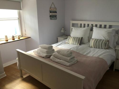 a bedroom with a bed with towels on it at Smugglers Well in Cellardyke