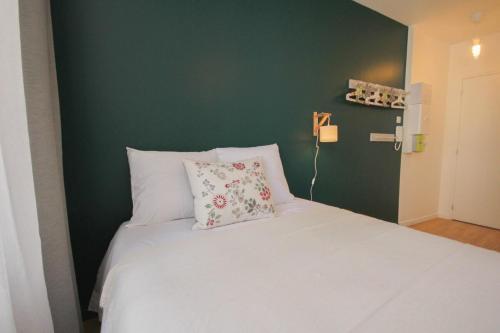 una camera con un letto bianco e una parete verde di Lille Grand Place - Nice and equipped studio! a Lille