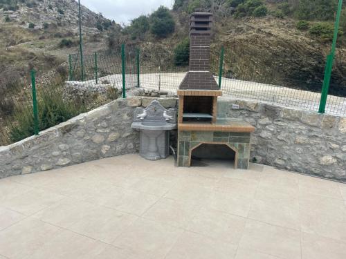a stone wall with a sink and a stone table at Qyteza Guest House & Camping in Renc