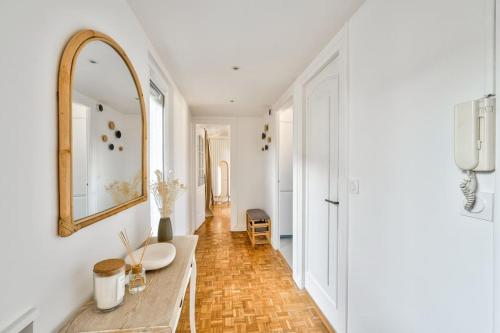 a hallway with a table and a mirror and a hallway with a hallway at Superbe appartement terrasse 75m Paris in Saint-Mandé