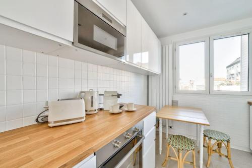 - une cuisine avec un comptoir et deux tabourets dans l'établissement Superbe appartement terrasse 75m Paris, à Saint-Mandé
