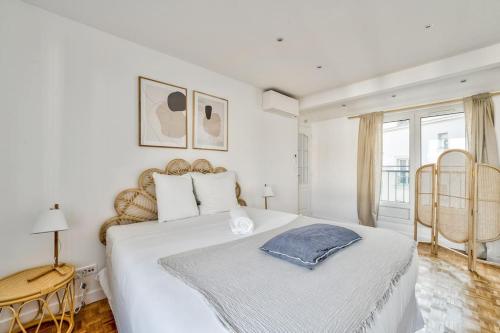 een witte slaapkamer met een groot bed en een raam bij Superbe appartement terrasse 75m Paris in Saint-Mandé