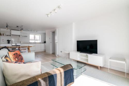 - un salon avec un canapé et une télévision dans l'établissement Belgravia Apartment 22, à Londres