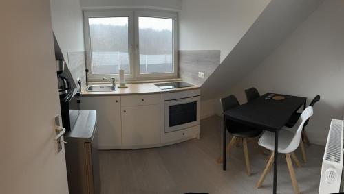 een kleine keuken met een wastafel en een tafel bij Ideale Unterkunft für Geschäftsreisende, Studenten, Monteure in Essen in Essen