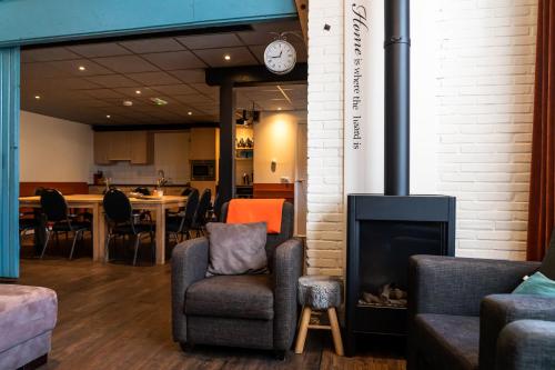 a living room with a fireplace and a dining room at De Johanneshoeve in Westerhaar-Vriezenveensewijk