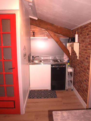 une petite cuisine avec un évier et une cuisinière dans l'établissement Studio Indépendant en Rez de jardin sans vis-à-vis, à Parcieux