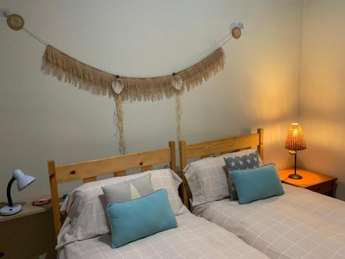 sypialnia z łóżkiem z niebiesko-białymi poduszkami w obiekcie Casa Major w mieście Mont-ral