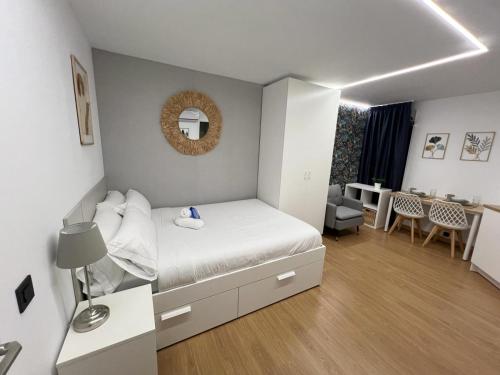 Dormitorio pequeño con cama y comedor en Modular Suites Alfonso Gómez, en Madrid