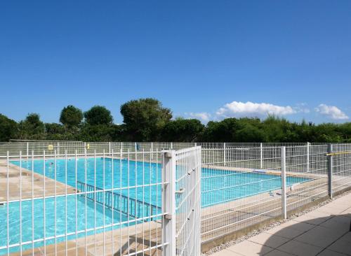 una gran piscina con una valla alrededor en Zeepolder III 157, en De Haan